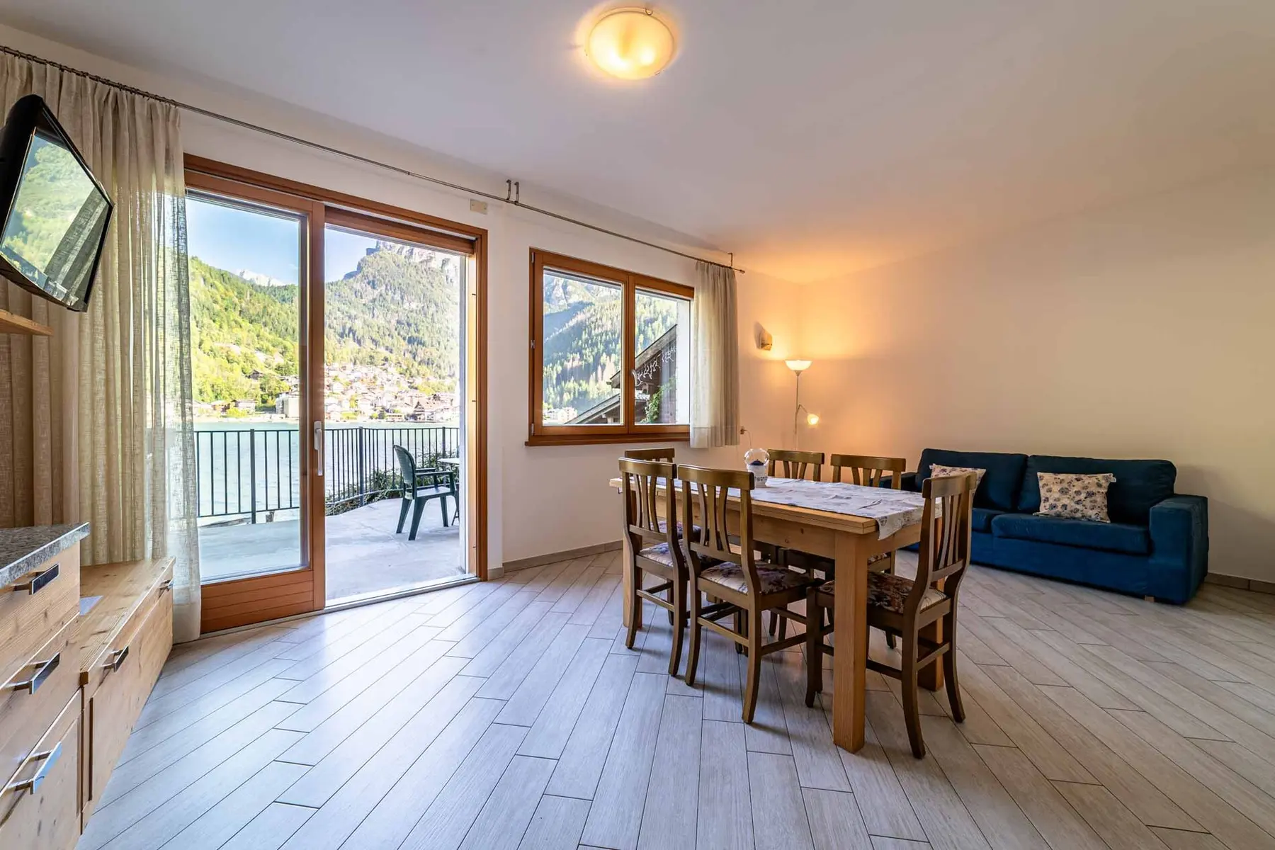 Soggiorno dello Chalet al Lago con grande vetrata sulla terrazza e sul lago di Alleghe